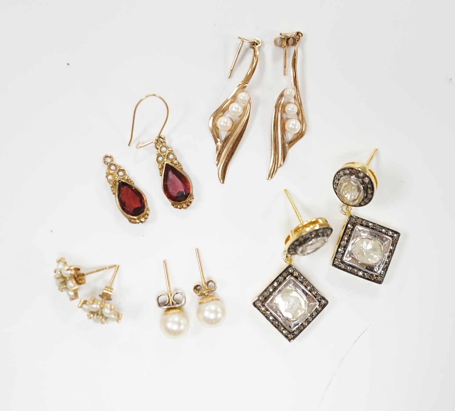A modern pair of 9ct and garnet? earrings, a pair of Indian? yellow metal and diamond cluster set drop earrings and three other pairs of yellow metal earrings including single stone cultured pearl.